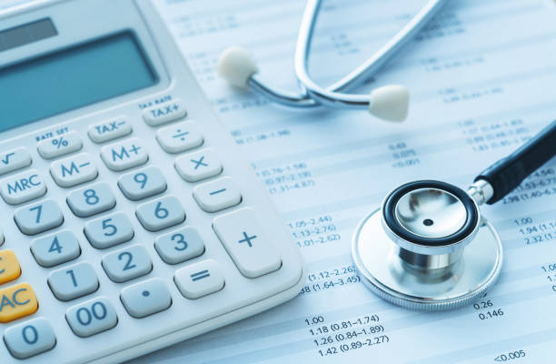 Une calculatrice et une stéthoscope sur un bureau pour prendre une mutuelle collective pour une PME.
